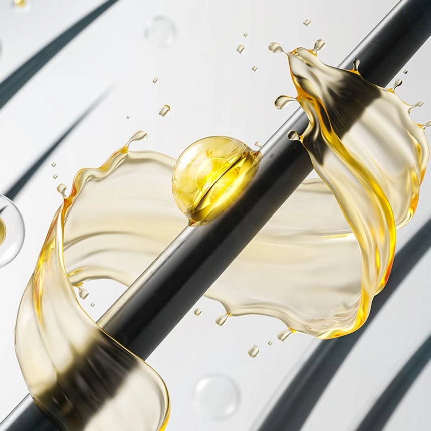 Ein goldgelber Flüssigkeitsspritzer wirbelt um einen glatten, dunklen Stab, in dessen Mitte sich ein durchscheinender Tropfen befindet. Der Hintergrund ist in hellen Grautönen gehalten und weist verschwommene diagonale Linien auf, die einen dynamischen, fließenden Effekt erzeugen.