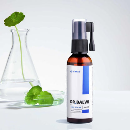 Eine braune Flasche Dr. Balwi Shop Anti Hair Loss Routine mit einer Sprühdüse steht neben einem durchsichtigen Becher und einer Petrischale, die beide grüne Blätter in Wasser enthalten, vor einem hellen Hintergrund.