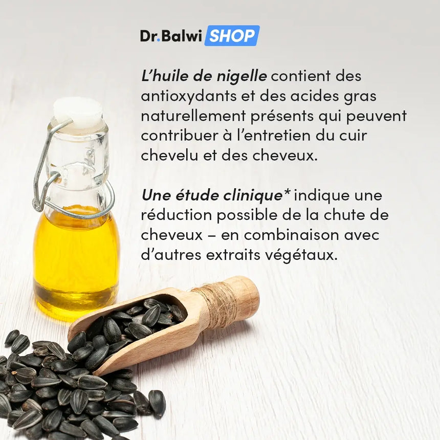 Eine kleine Glasflasche mit gelbem Öl steht neben einer Holzkelle mit schwarzen Samen, die auf einer hellen Fläche verstreut sind. Ein französischer Text daneben beschreibt die Vorteile von Nigellaöl für das Haar.