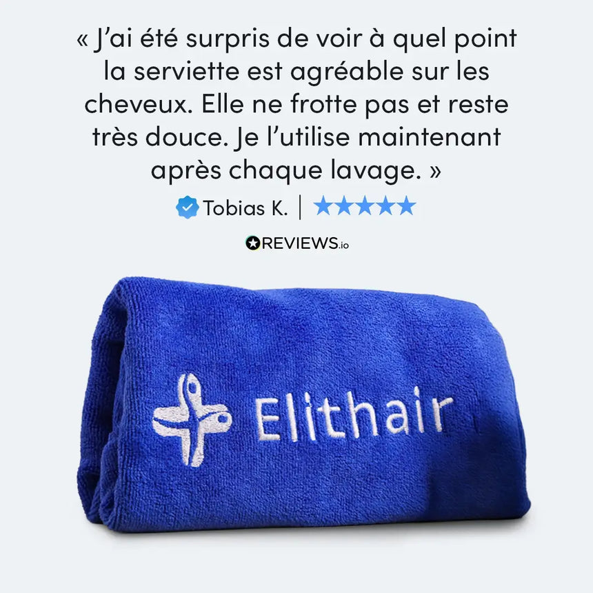 Ein gefaltetes blaues Handtuch mit weißer Elithair-Stickerei ist abgebildet. Über dem Handtuch steht eine französische Kundenrezension, in der die Weichheit für das Haar gelobt wird, zusammen mit einer 5-Sterne-Bewertung und dem Namen Tobias K.