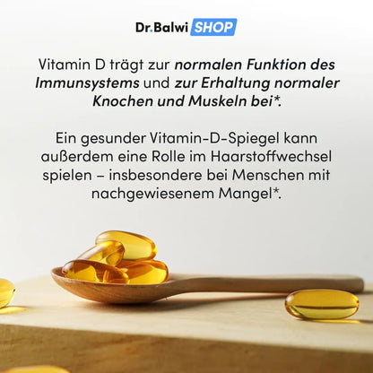 Ein Holzlöffel mit gelben Vitamin D 1000 IE Kapseln von Dr. Balwi Shop liegt auf heller Fläche, daneben weitere Kapseln. Im Hintergrund Hinweise zu Vorteilen von Vitamin D und seinem Zusammenhang mit Haarausfall.