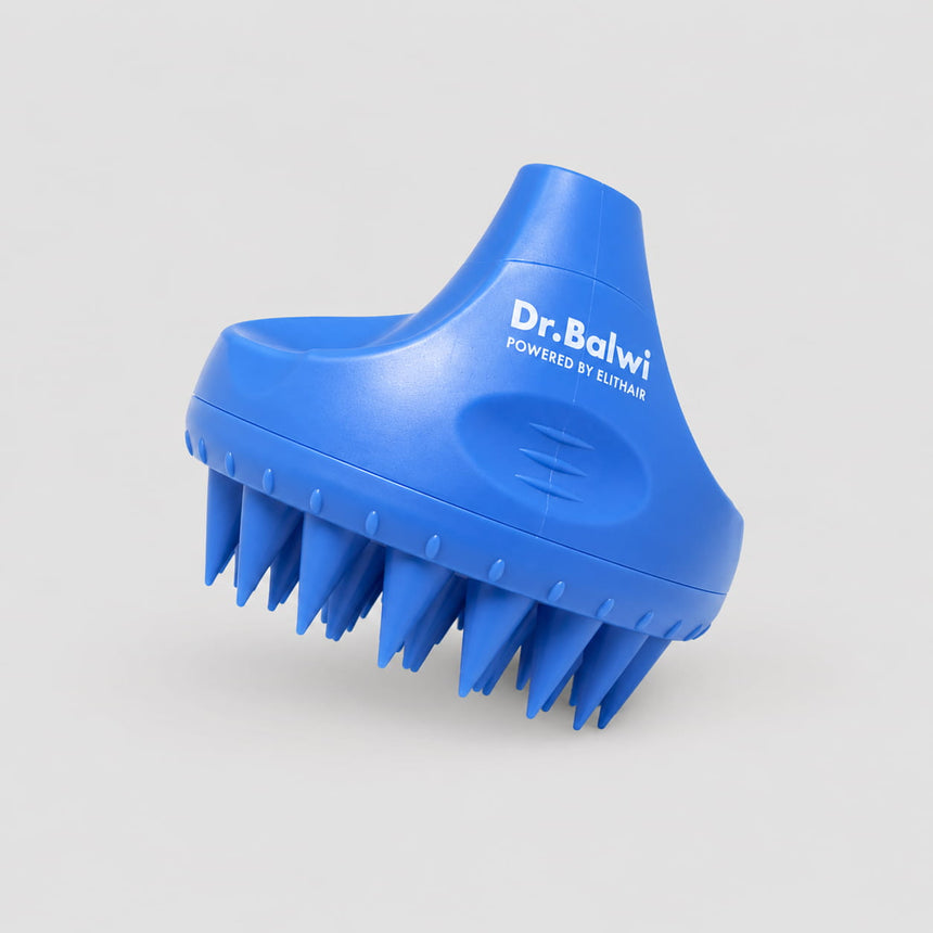Eine blaue Dr. Balwi-Massagebürste aus dem Dr. Balwi Shop mit zahlreichen weichen, spitzen Borsten und dem Aufdruck „Dr. Balwi POWERED BY ELITHAIR“ an der Seite, wird vor einem schlichten hellgrauen Hintergrund präsentiert – ideal als Kopfhautmassagegerät (Massagebürste) für eine belebende Kopfmassage zur Förderung des Haarwachstums.